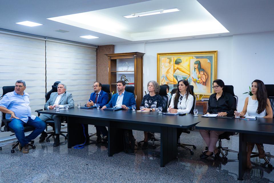quatro mulheres e quatro homens reunidos em uma mesa discutindo sobre o plano 2045